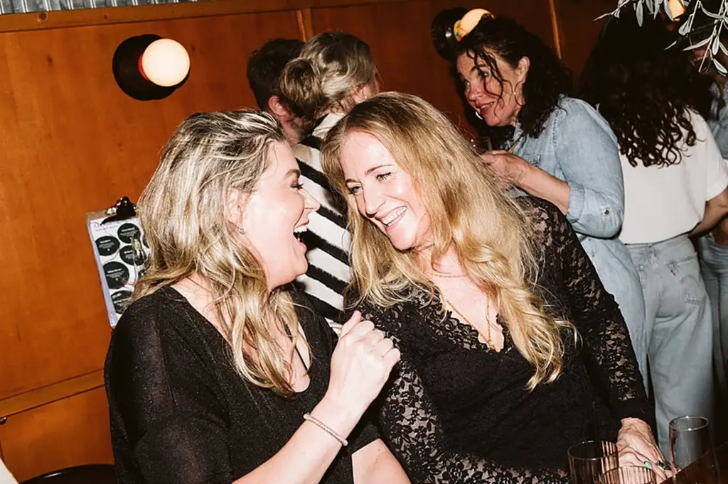 Twee vrouwen lachen en dansen samen