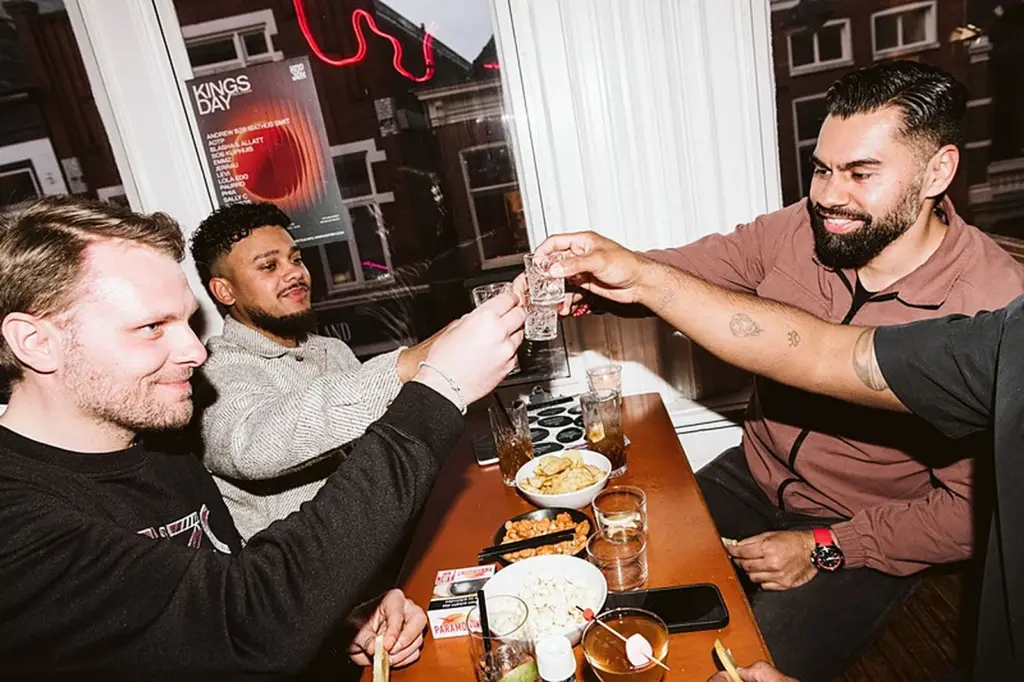 Vrienden proosten met een shotje aan tafel