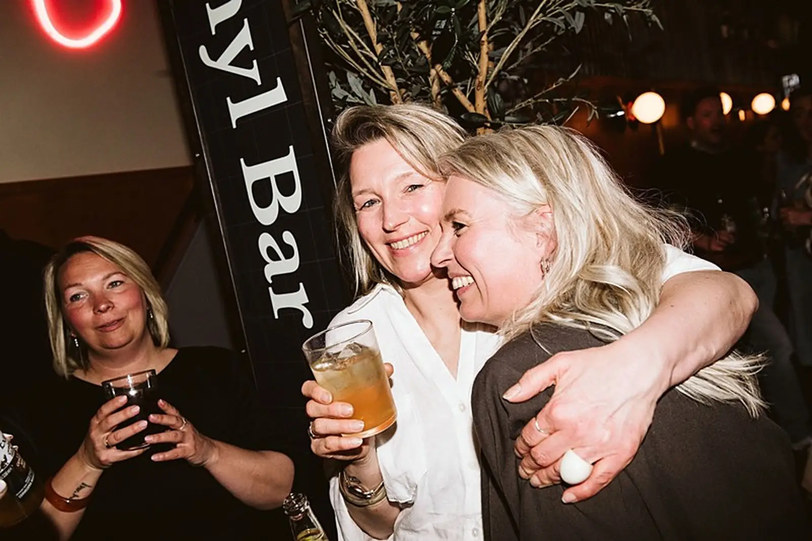 Twee vriendinnen lachen met een drankje aan de bar